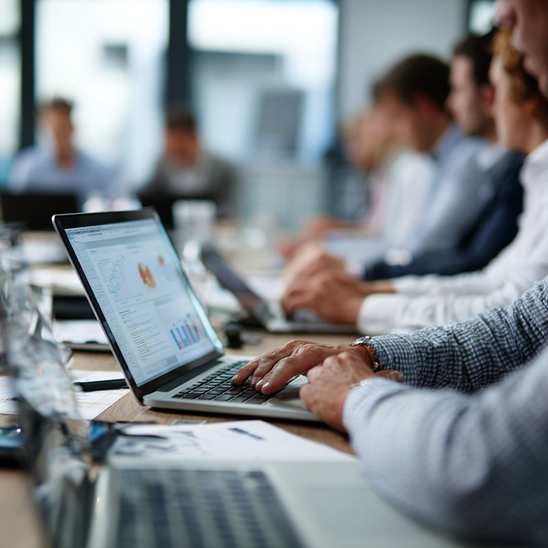 Close-up of employees engaged in collaborative corporate training using LMS tools and digital learning modules.